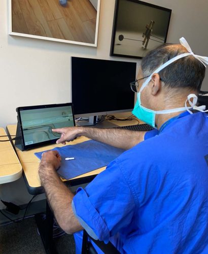 Doctor pointing at laptop screen showing his guidewire within a simulated lesion